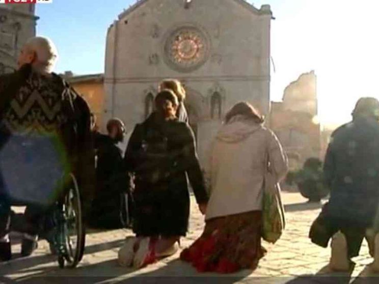 In ginocchio di fronte alla basilica sventrata