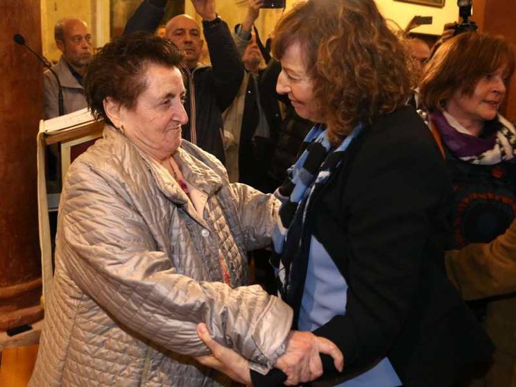 L'abbraccio fra i parenti del martire e la figlia del partigiano che lo uccise