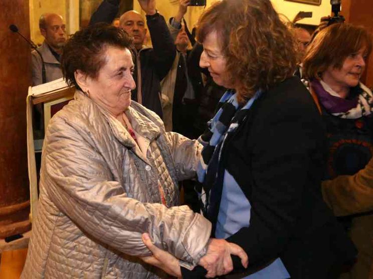 L'abbraccio fra i parenti del martire e la figlia del partigiano che lo uccise