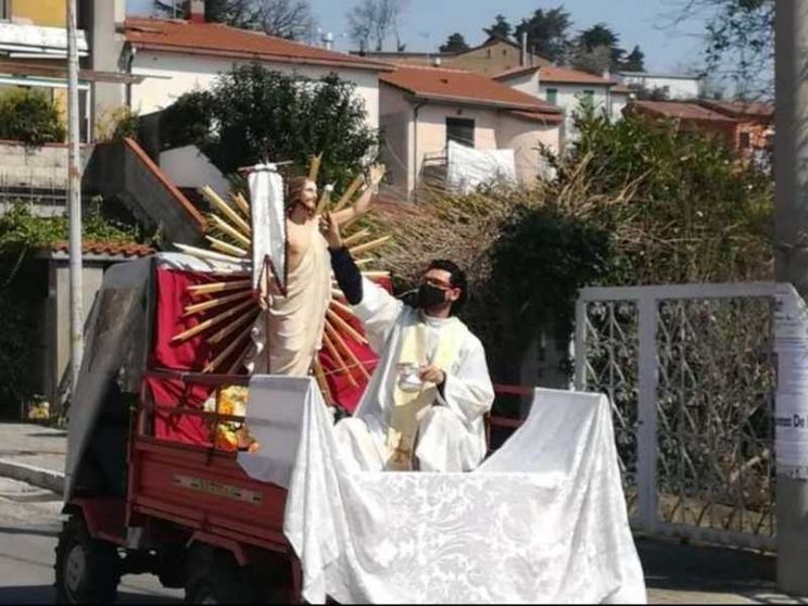 Dal trattore il parroco benedice i paesi con il Cristo Risorto