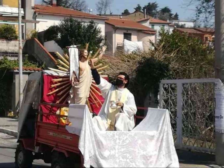 Dal trattore il parroco benedice i paesi con il Cristo Risorto
