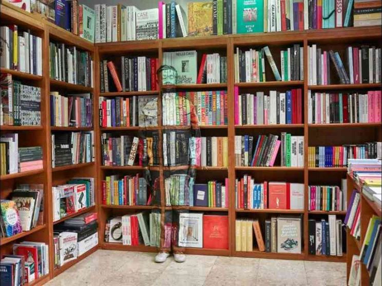Liu Bolin, ecco l'invisibile fra i libri della Hoepli