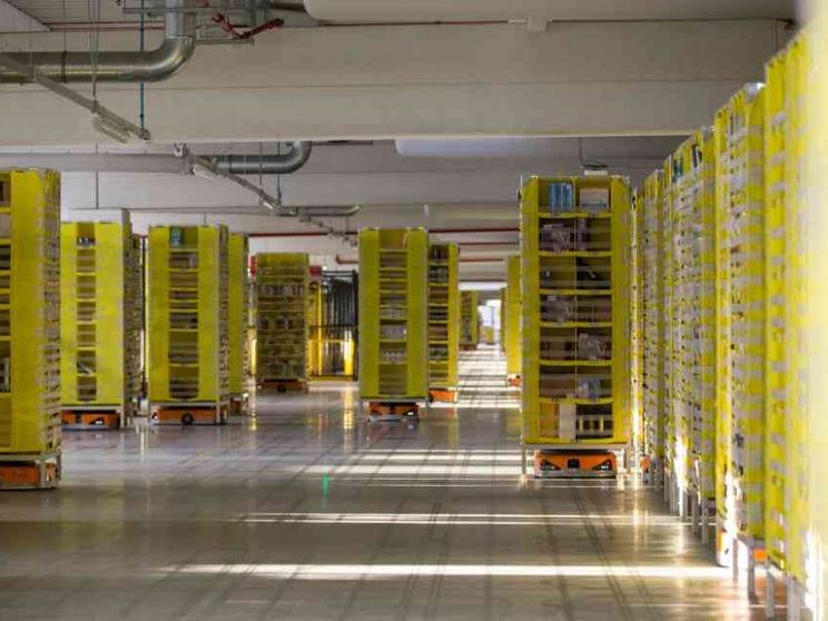 Uomini e macchine lavorano insieme nella base Amazon del Centro Italia