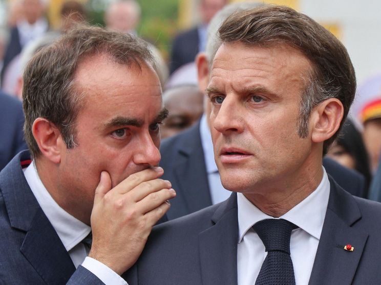 Lecornu sussurra all'orecchio di Macron, che lo ascolta con fronte corrugata