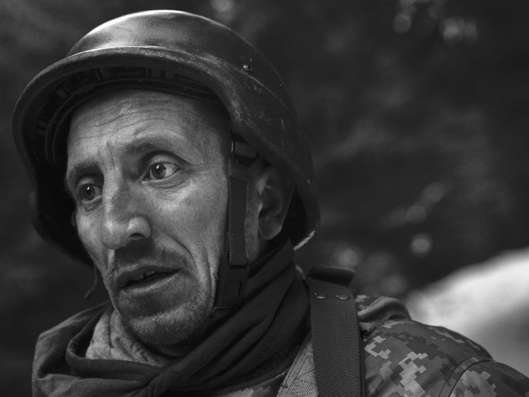 Il ritratto, in primo piano, di un soldato ucraino, con l'elmetto, durante un addestramento