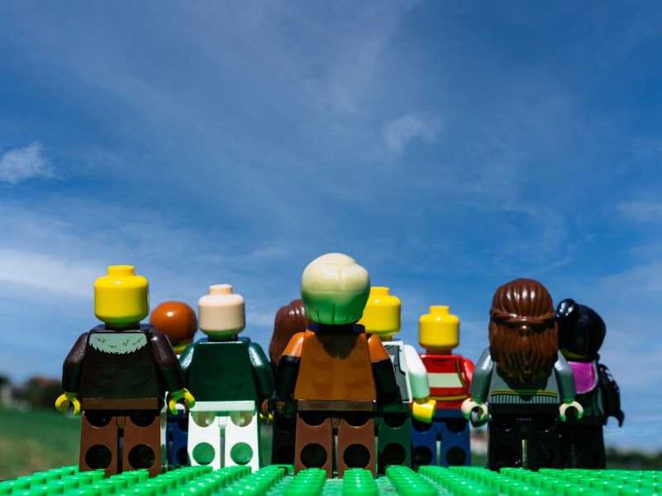 Nove omini Lego si muovono su un prato e guardano un cielo che diventa sempre più blu
