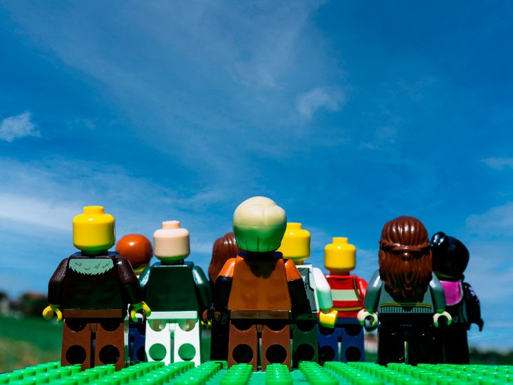 Nove omini Lego si muovono su un prato e guardano un cielo che diventa sempre più blu