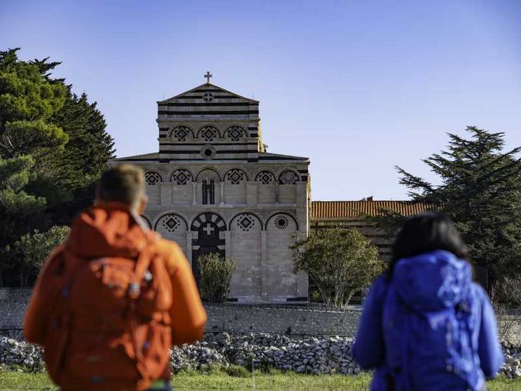 Due camminatori, zaino in spalla, si dirigono verso il Monastero di San Pietro di Sorres a Borutta