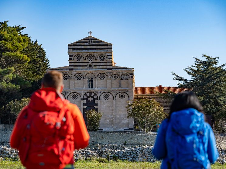 Due camminatori, zaino in spalla, si dirigono verso il Monastero di San Pietro di Sorres a Borutta