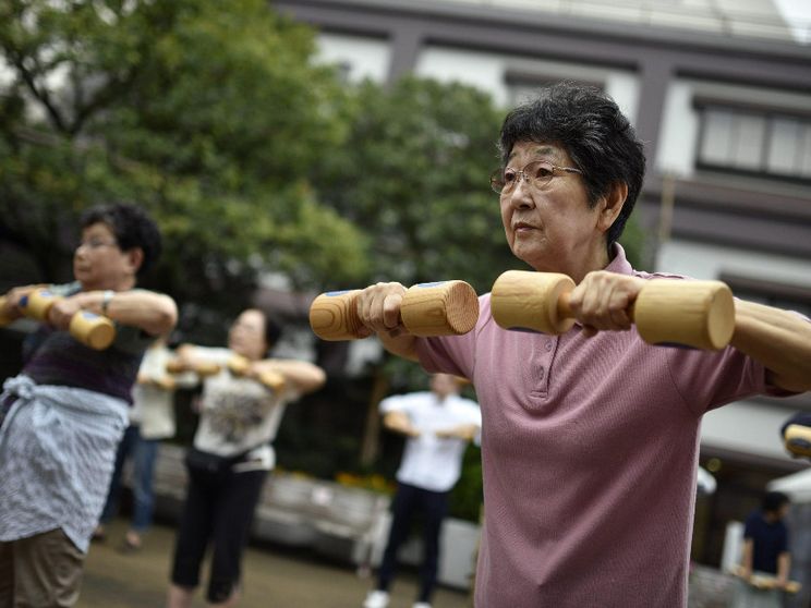 Anziani fanno ginnastica in un parco pubblico a Tokyo