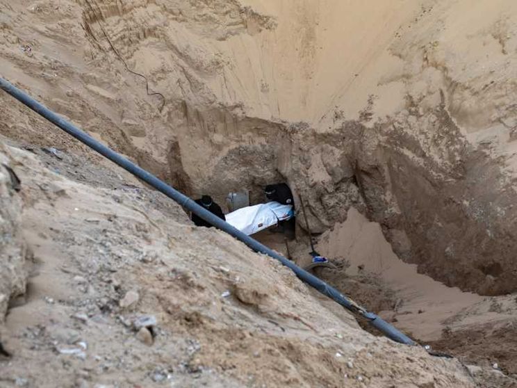 Miliziani di Hamas seppelliscono il corpo di un israeliano dopo averlo recuperato da un tunnel in Khan Yunis, nel sud di Gaza