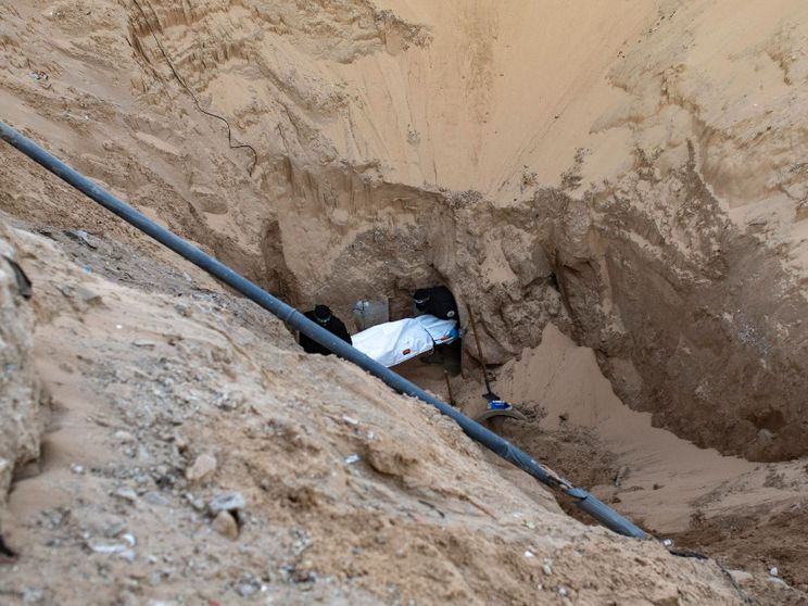 Miliziani di Hamas seppelliscono il corpo di un israeliano dopo averlo recuperato da un tunnel in Khan Yunis, nel sud di Gaza