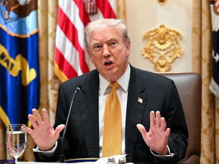 Un primo piano di Trump che mette le mani avanti, con i palmi aperti