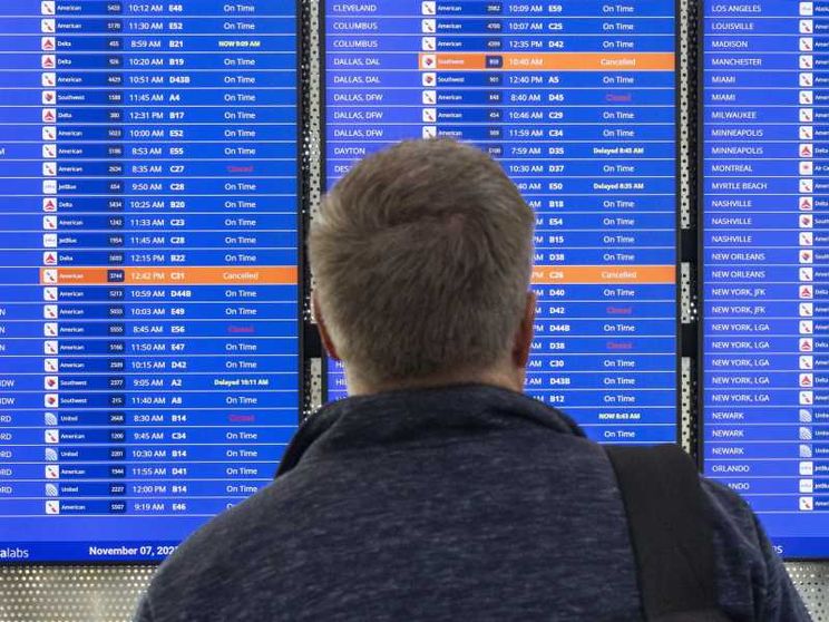 Un passeggero guarda il tabellone dove i voli Usa stanno ritornando regolari. Lo shutdown ha gettato nel caos il traffico aereo americano
