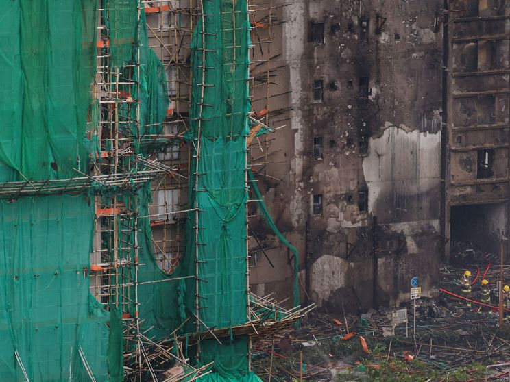Quel che resta delle impalcature di bambù sui grattacieli bruciati a Hong Kong