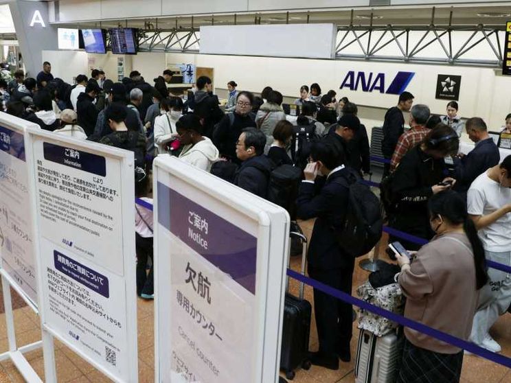 Passeggeri in fila all'Haneda Airport di Tokyo, dopo la cancellazione dei voli