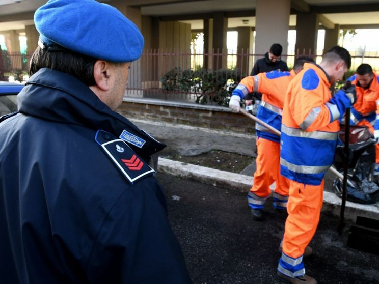 Detenuti impegnati in lavori socialmente a Roma sotto lo sguardo di un agente penitenziario