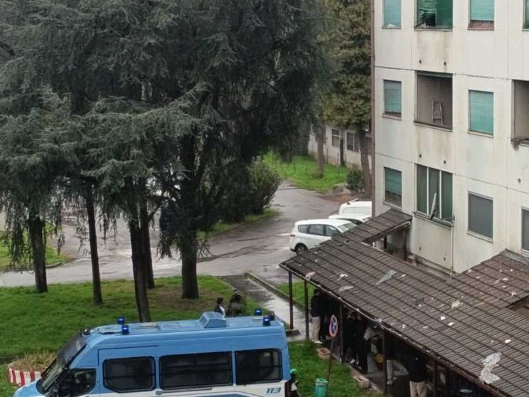 Una camionetta della polizia all'esterno del palazzo di via Quarti, 31 a Milano, dove è stata eseguita l'ordinanza di sgombero