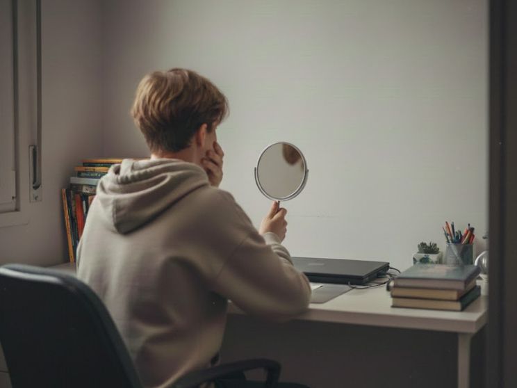 Un ragazzino si guarda allo specchio