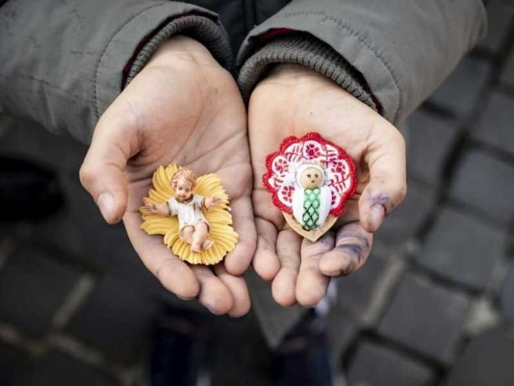 Le statuine di Gesù bambino in mano a un ragazzino in piazza San Pietro