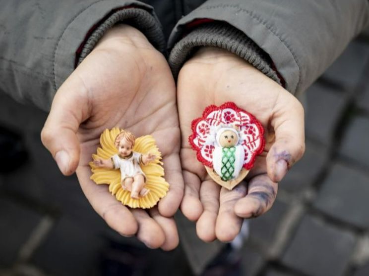 Le statuine di Gesù bambino in mano a un ragazzino in piazza San Pietro