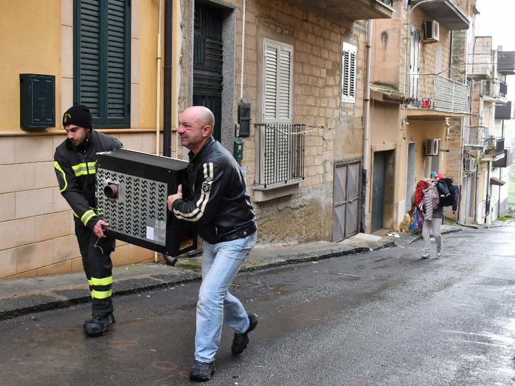 Volontari della Protezione civile e comuni cittadini aiutano le persone a svuotare le proprie case in bilico sull'abisso, a Niscemi / ANSA