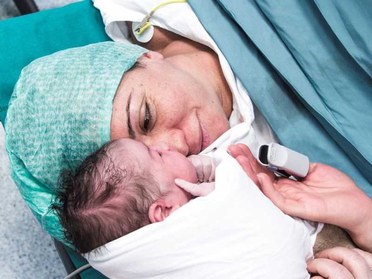 Una madre col suo bambino in sala parto