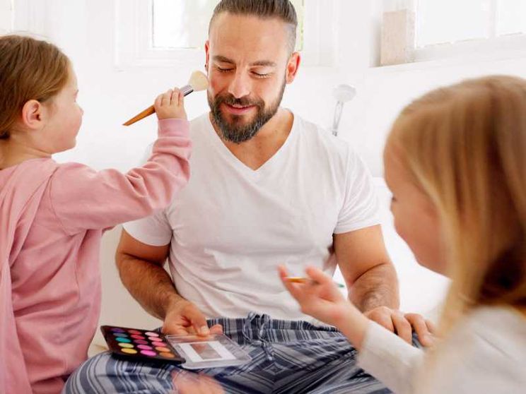 Due bimbe truccano il loro papà