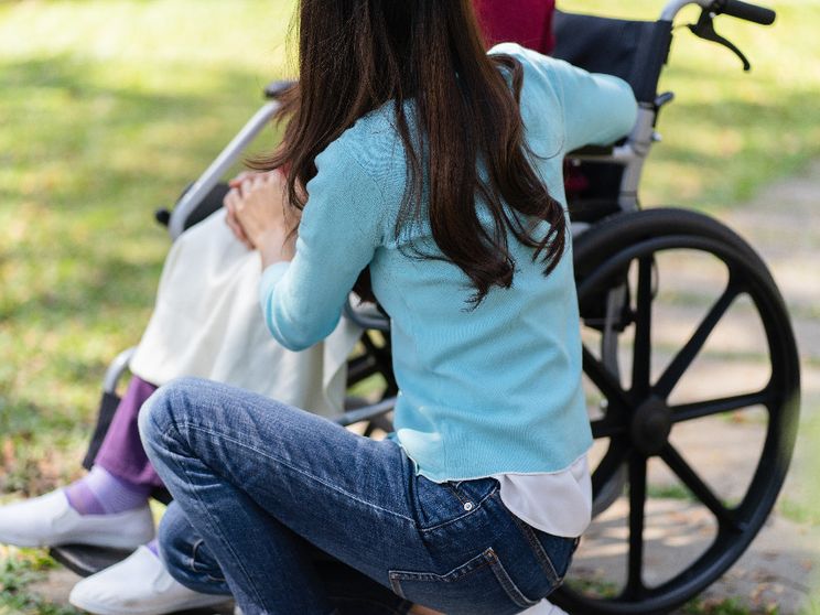 Nella fotografia si vede una giovane donna che assiste una signora anziana in carrozzina /Foto Icp