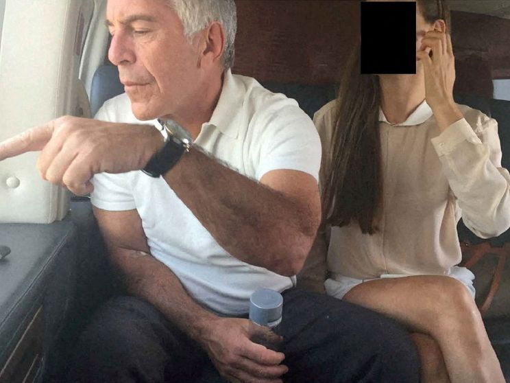 Il finanziere Jeffrey Epstein a bordo di un aereo indica qualcosa dal finestro. Al suo financo una donna il cui volto è stato oscurato per ragioni di riservatezza
