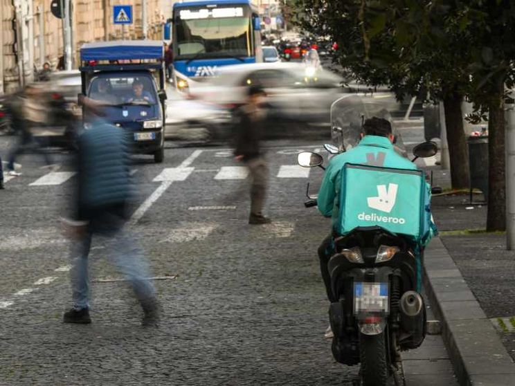 Un rider Deliveroo in attesa di chiamata a Napoli / Ansa
