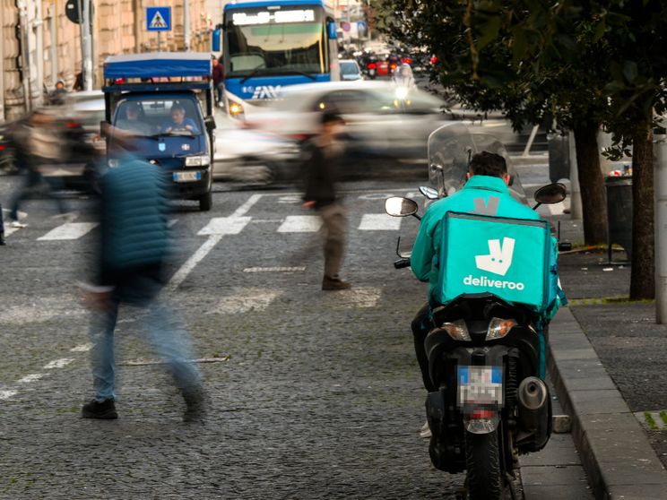 Un rider Deliveroo in attesa di chiamata a Napoli / Ansa