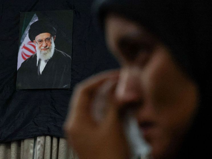 Una donna piange davanti alla foto dell'ayatollah Khamenei
