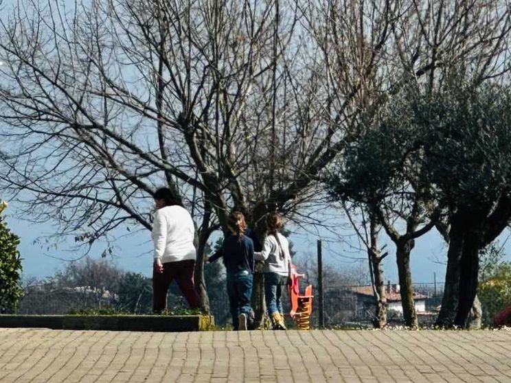 Zia Rachel passeggia nel cortile della casa famiglia di Vasto insieme a due dei suoi tre nipoti, i figli della famiglia nel bosco
