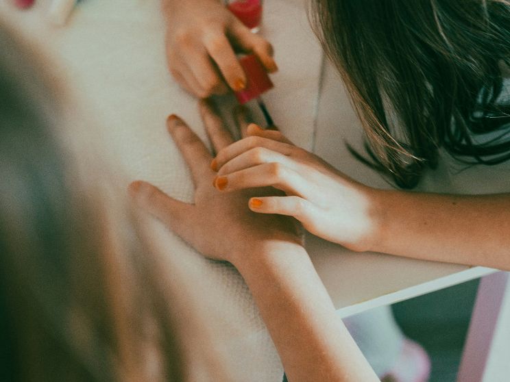Una bimba gioca a fare lo smalto a una sua amichetta