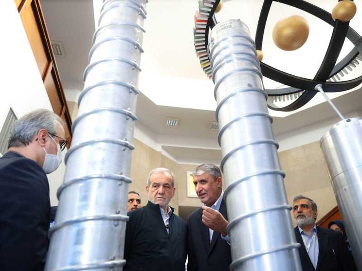 Un gruppo di funzionari iraniani e il presidente Massud Pezeshkian ispezionano dei grandi cilindri grigi in uno degli impianti del programma nucleare