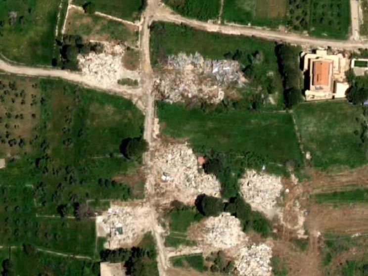 Un'immagine satellitare mostra varie chiazze bianche dove prima c'erano case e infrastrutture