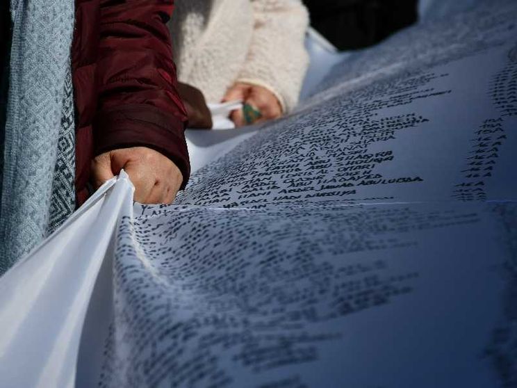 Un gruppo di volontari trasporta il sudario con i dati dei minori morti nella Striscia di Gaza