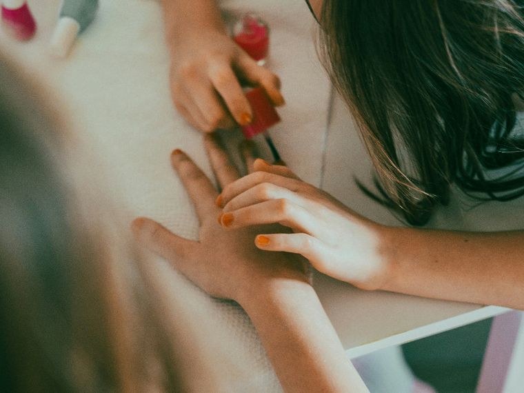 Una bimba gioca a fare lo smalto a una sua amichetta