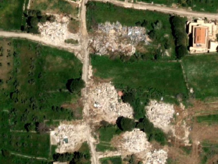 Un'immagine satellitare mostra varie chiazze bianche dove prima c'erano case e infrastrutture
