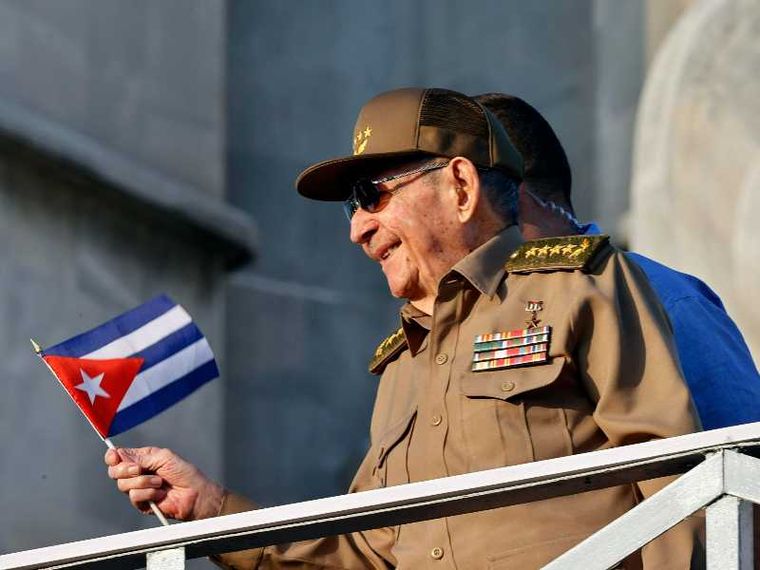 Un uomo si sporge da un parapetto con una bandiera cubana in mano. Si tratta di Raul Castro, ex presidente cubano