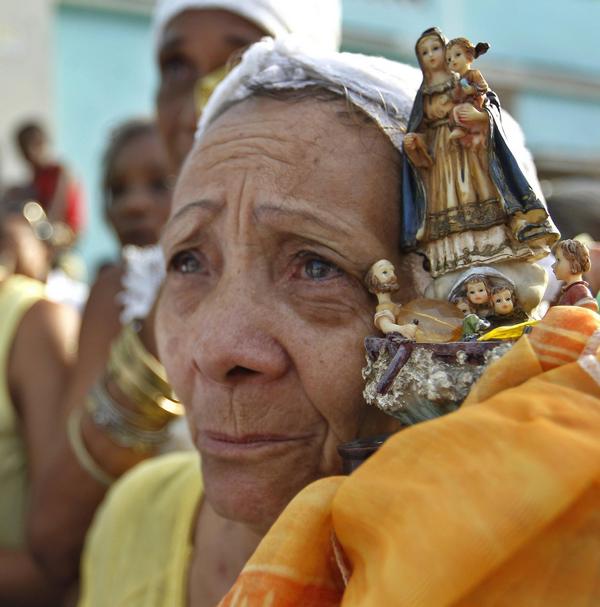 Un'immagine simbolica da Cuba: un, naziana donna con la statuetta della Vergine della Carità all'Avana  (Ansa)