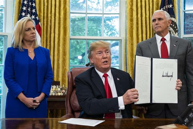 Trump mostra la sua firma sull'ordine esecutivo, al suo fianco i ministri Kirstjen Nielsen e Jeff Sessions (Ansa)