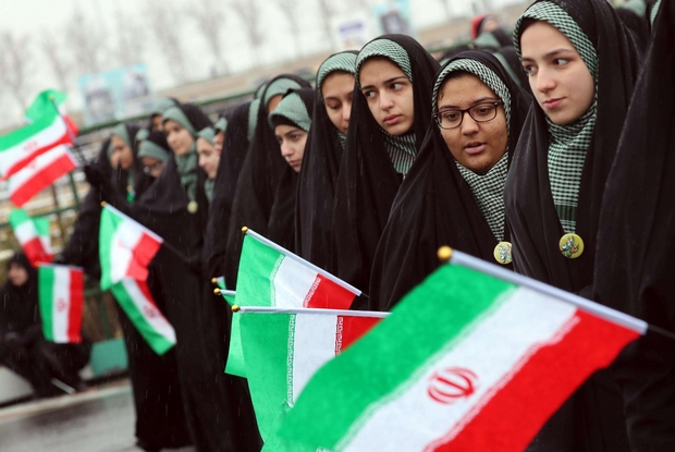 Donne iraniane velate sventolano la bandiera nazionale per i quarant'anni della rivoluzione Khomeneista (Ansa)