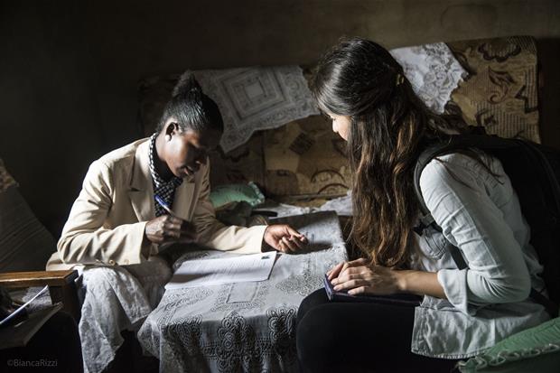 Una studentessa italiana informa una madre del villaggio (Foto Bianca Rizzi)