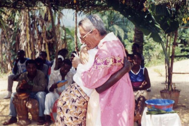padre Pierino Zoni, mentre abbraccia una donna africana.