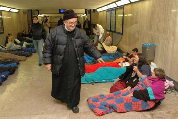 Don Benzi mentre saluta alcuni senzatetto