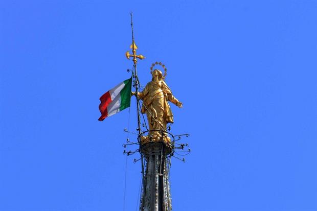 IlIl tricolore della bandiera italiana issato sulla guglia maggiore del Duomo di Milano, accanto alla Madonnina
