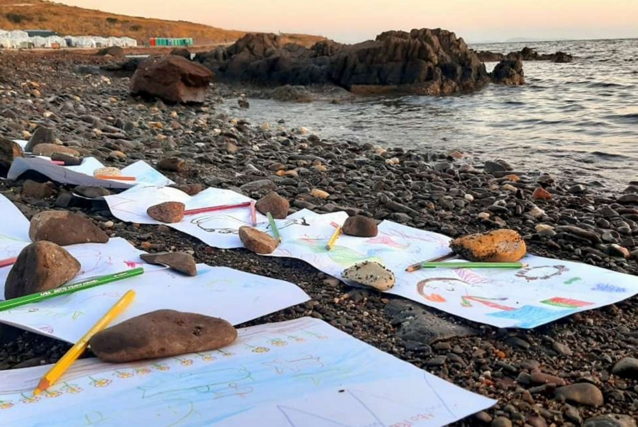 sassi e disegni lasciati in riva al mare, da dove molti di loro sono sbarcati'