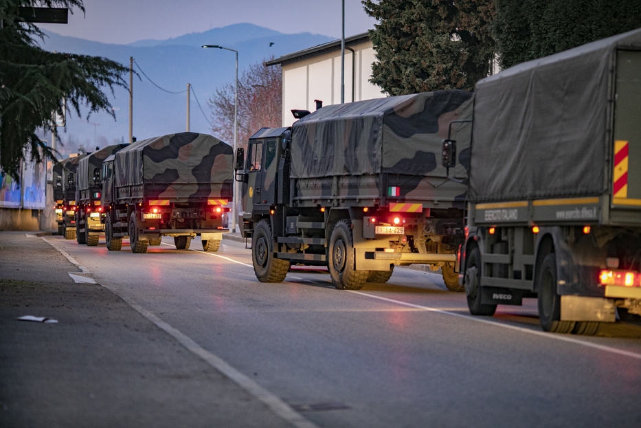 Camion militari portano via le bare da Bergamo